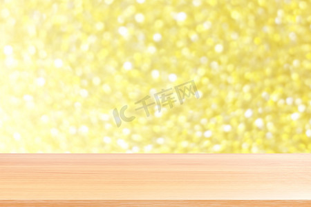 模糊的金色闪光散景灯上的木板闪耀背景，抽象背景金色闪光散景上空的木桌板，金色琥珀色灯光背景上空的木桌板