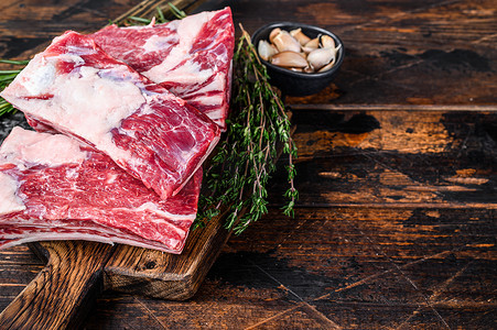 生牛肉小牛排骨肉在屠夫砧板上用切肉刀。