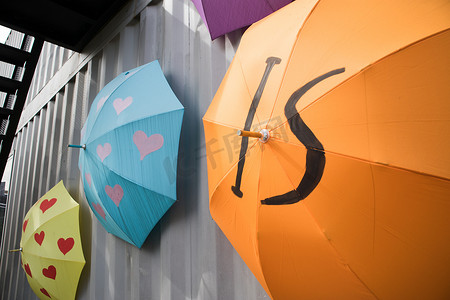 五颜六色的装饰伞挂在集装箱的一侧，装饰得像当代艺术。
