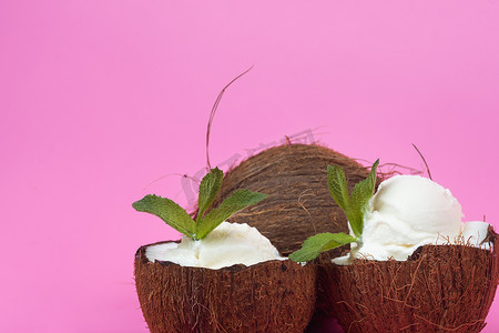 新鲜椰子半香草冰淇淋球，粉红色背景上装饰着薄荷叶