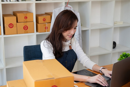 开始小企业企业家 SME 自由职业者，在家办公室工作的肖像年轻女性，BOX，智能手机，笔记本电脑，在线，营销，包装，交付，SME，电子商务概念。