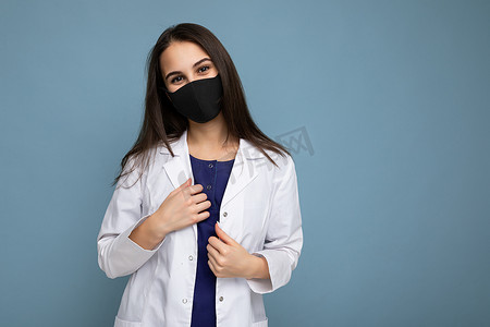 脸上戴着病毒防护面具的妇女，可抵御冠状病毒，蓝色背景中隔离有白色医用外套