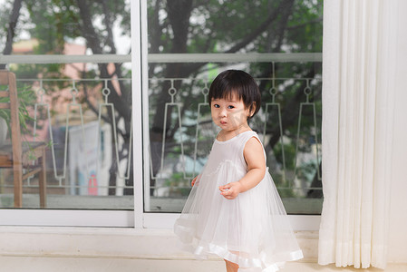 亚洲第一摄影照片_在家窗边玩耍的可爱亚洲小女孩