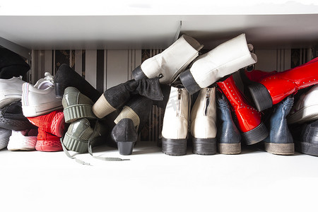 在鞋架中收集旧的不同鞋子以供存放、杂乱和需要整理、带架子的衣柜在室内设计中