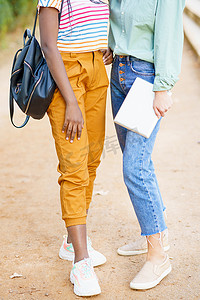 两个面目全非的多民族女孩穿着色彩缤纷的休闲服合影