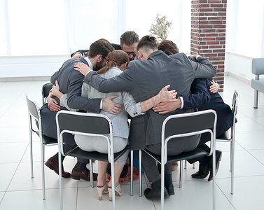 业务团队坐成一圈，互相拥抱