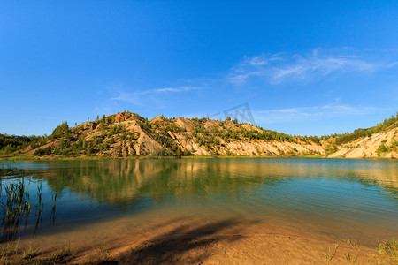 png绿水摄影照片_有沙滩、绿水、树木和蓝天的山丘的采石场或湖泊或池塘