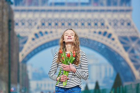 埃菲尔铁塔红色摄影照片_埃菲尔铁塔附近拿着一束红色郁金香的女孩