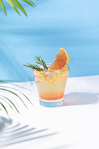 冷而清爽的橙色潘趣鸡尾酒，颜色背景上有橙色切片。