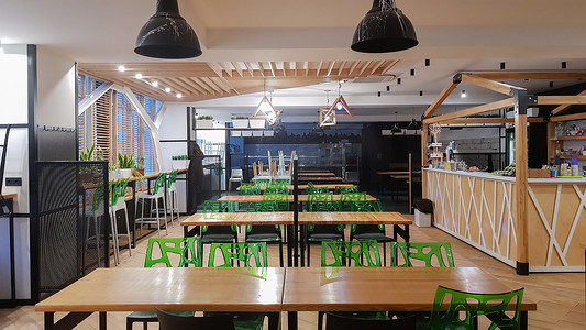 自助餐厅，没有人的餐厅，有木桌和绿色椅子。