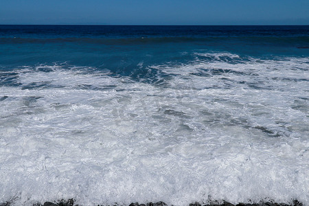 海上三四点有小风暴，海浪带着大卵石冲击岸边。