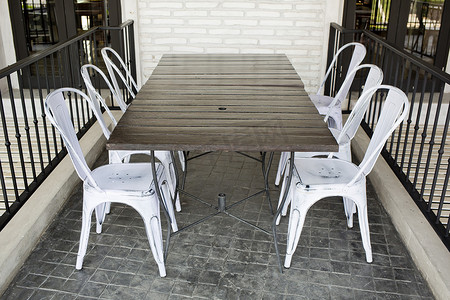 餐厅露台砖块地上的白色塑料椅子