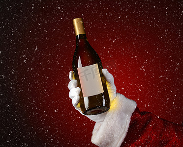 圣诞老人拿着雪花效果的霞多丽酒瓶