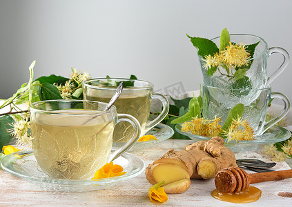 菩提树摄影照片_白木上的透明杯子，配有生姜和菩提树的茶