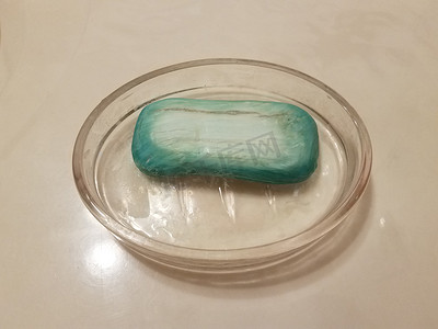 浴室柜台上有旧蓝色肥皂的玻璃碗