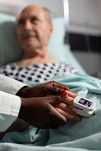 有爱心的友好非洲裔美国医生握着老年病人的手