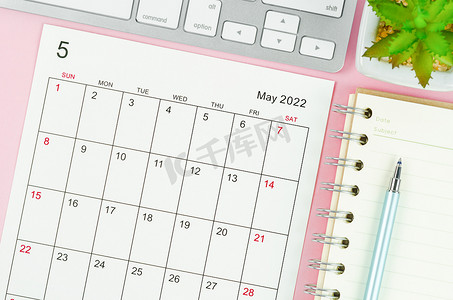 2022 年 5 月带有粉红色背景键盘计算机的日历表。
