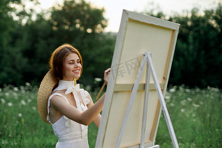 白裙摄影照片_穿白裙的女人在户外爱好创意上画画