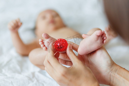 婴儿按摩小手摄影照片_母亲握住新生婴儿的脚。