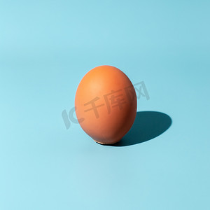 极简创意海报摄影照片_在蓝色背景的鸡蛋。