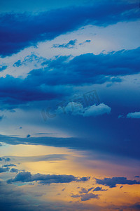 日落日出摄影照片_与蓝色和金色颜色的垂直的云彩日落日出