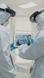 放射防护摄影照片_专业正畸医生在数字平板电脑上查看牙科 X 光片