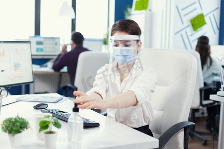 大唐经理摄影照片_企业家佩戴面罩和面罩，使用凝胶进行手部卫生