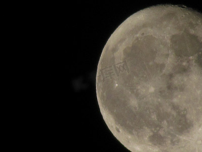 黑色月球摄影照片_通过长焦相机拍摄的黑色夜空中的月亮特写。