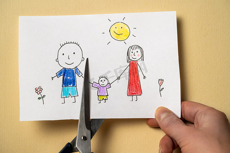 描绘妈妈、爸爸和孩子的儿童画是用剪刀剪下来的。