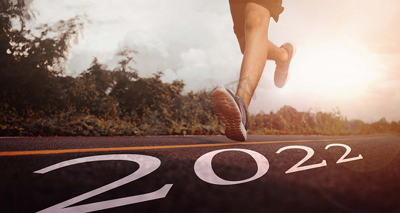 新年伊始，运动鞋中跑步者脚的特写，愿景和新想法从 2022 年开始。在 2022 年实现目标并采用成功的概念。