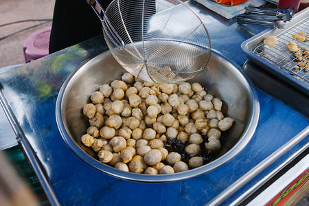 民间菜摄影照片_烹调 将鱼丸放入热油锅中煎炸。