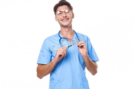 身穿医疗制服的男子戴着眼镜听诊器摆在浅色背景中