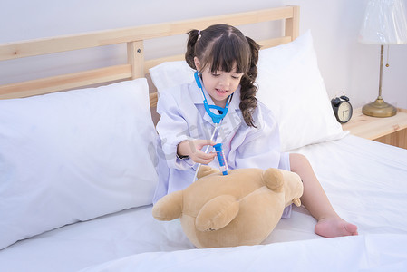 可爱的亚洲小女孩喜欢在家里玩医生玩具和可爱的洋娃娃