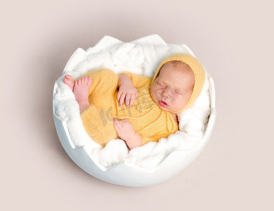 睡觉的新生儿蜷缩在圆篮子上