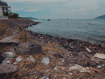 很多垃圾散落在地上，浪费在海滩上的海边。