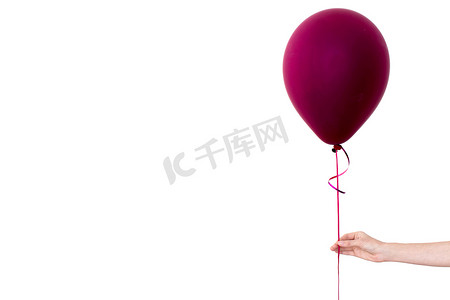 女人的手拿着紫色气球白色背景