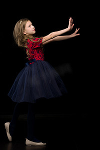 身着芭蕾舞裙的漂亮女孩手牵手站在面前的侧视图