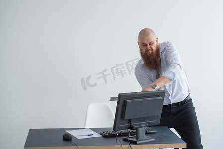 强调疯狂的商人在办公室使用斧头问题概念砸碎他的电脑。