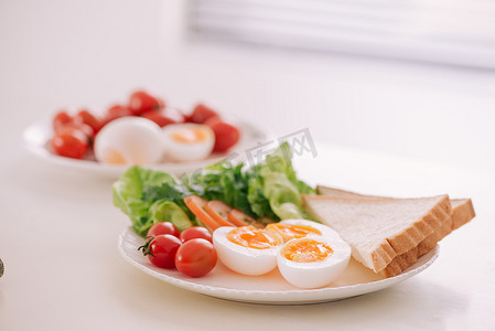 新鲜的花园沙拉配鸡蛋、鳄梨和西红柿，放在褐砂石菜肴中，是一顿健康的低热量午餐。