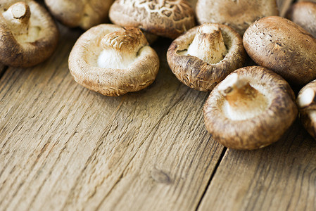 香菇终结者摄影照片_木桌背景上的新鲜蘑菇 — 香菇