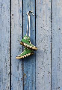 绿色经典摄影照片_绳子上挂着一双旧纺织绿色经典运动鞋