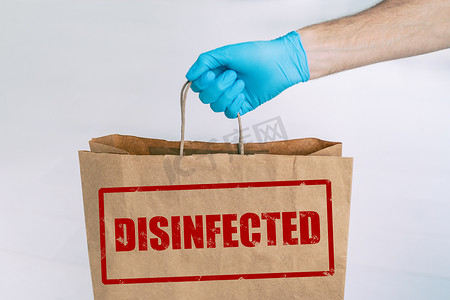 从在线杂货店购物到家的送货袋，纸面写有安全标记 DISIFINFECTED。