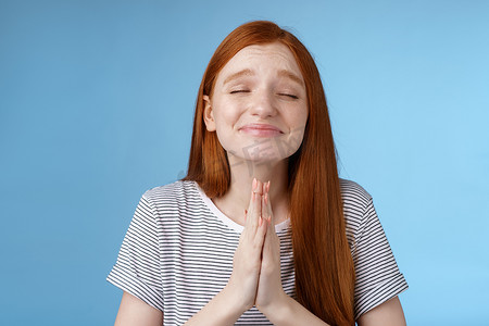 许愿的女孩心底愿意梦想成真双手合十祈祷祈求闭上眼睛微笑真诚的信念愿望实现期待奇迹，站在蓝色背景