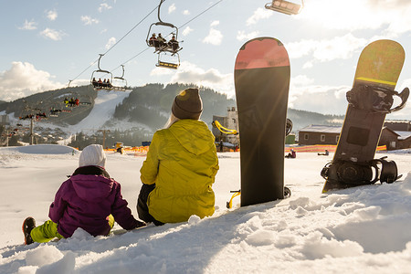 一家人带着滑雪板在冬季度假胜地玩雪