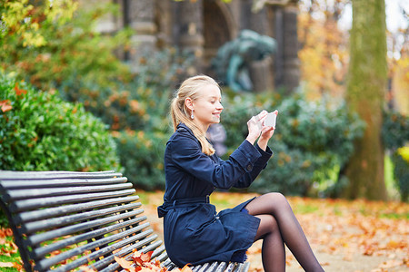 巴黎街头美丽的年轻女子用手机自拍