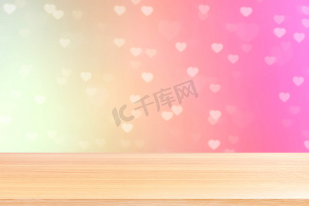 散景灯上的空木桌地板心形柔和的粉红色背景，木桌板前空的散景心形多彩，木板空白在多彩的散景闪耀心形柔和的粉红色