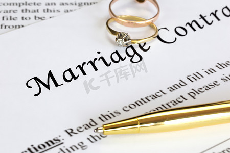 与两个金婚戒指和金笔的婚姻合同，婚前协议，宏观特写，签名，文件，协议概念