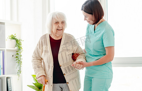 护理人员帮助老年妇女走路