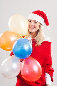 戴着圣诞帽的女人拿着一堆气球