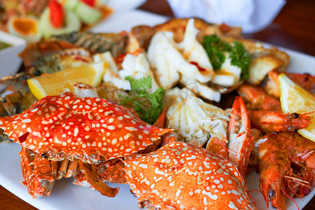 大盘子上的海鲜包括虾、柠檬、鱿鱼和蟹壳